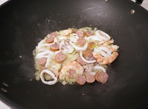 用奶油炒香洋蔥末、蒜末，再放入蝦子、花枝、火腿丁拌炒