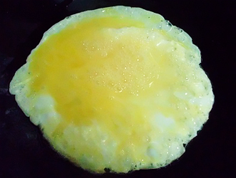 將蛋液淋在鍋內均勻平鋪，待平均受熱後再翻面煎熟。