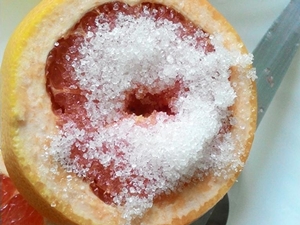 在葡萄柚上放上一大匙的砂糖。