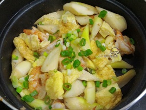 接著放入筊白筍，米酒嗆鍋後加入水，蓋鍋，這時把歐姆蛋切塊狀，煮到筊白筍軟化，蛋塊和蝦球一起拌炒，調味後放入蔥花，即可起鍋！