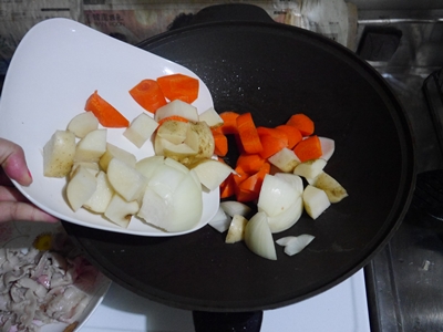 接著將洋蔥、紅蘿蔔、馬鈴薯一起放入鍋中，稍微拌炒至所有材料都沾上油。