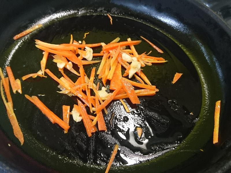 先用平底鍋爆炒大蒜末後，放紅蘿蔔下去炒