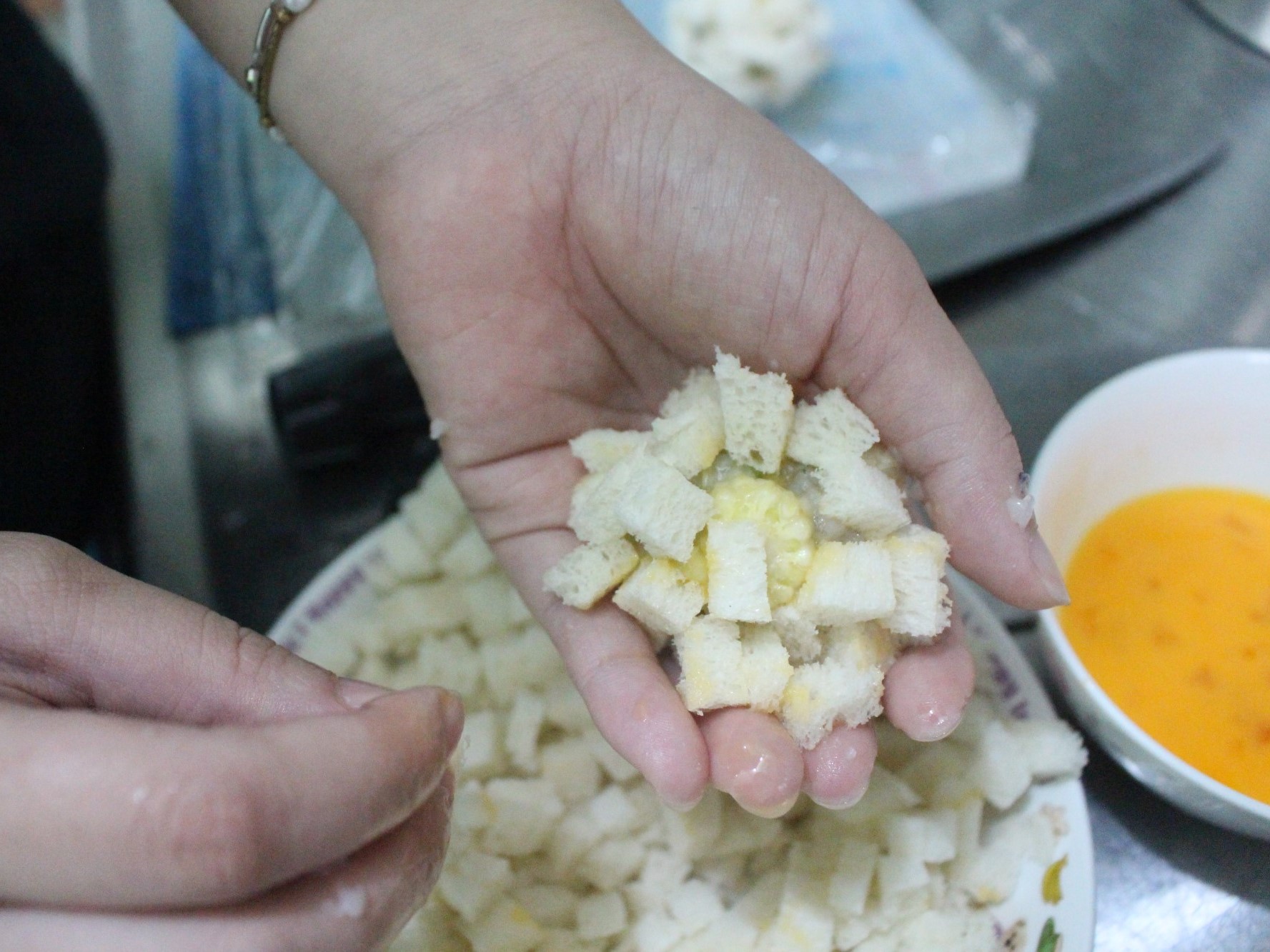 揉成球後，將玉米筍蝦球沾滿蛋液，裹上吐司丁。