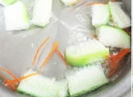 在鍋中放入500cc的水或高湯煮滾，接著放入絲瓜與紅蘿蔔絲，繼續加熱