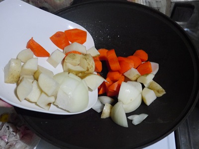 接著將洋蔥、紅蘿蔔、馬鈴薯一起放入鍋中，稍微拌炒至所有材料都沾上油