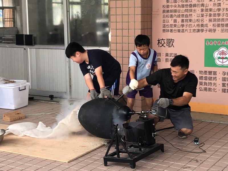 同學們分組操作爆米香機器。