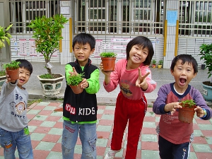 捧著種植成功的羅漢松盆栽，小朋友好開心